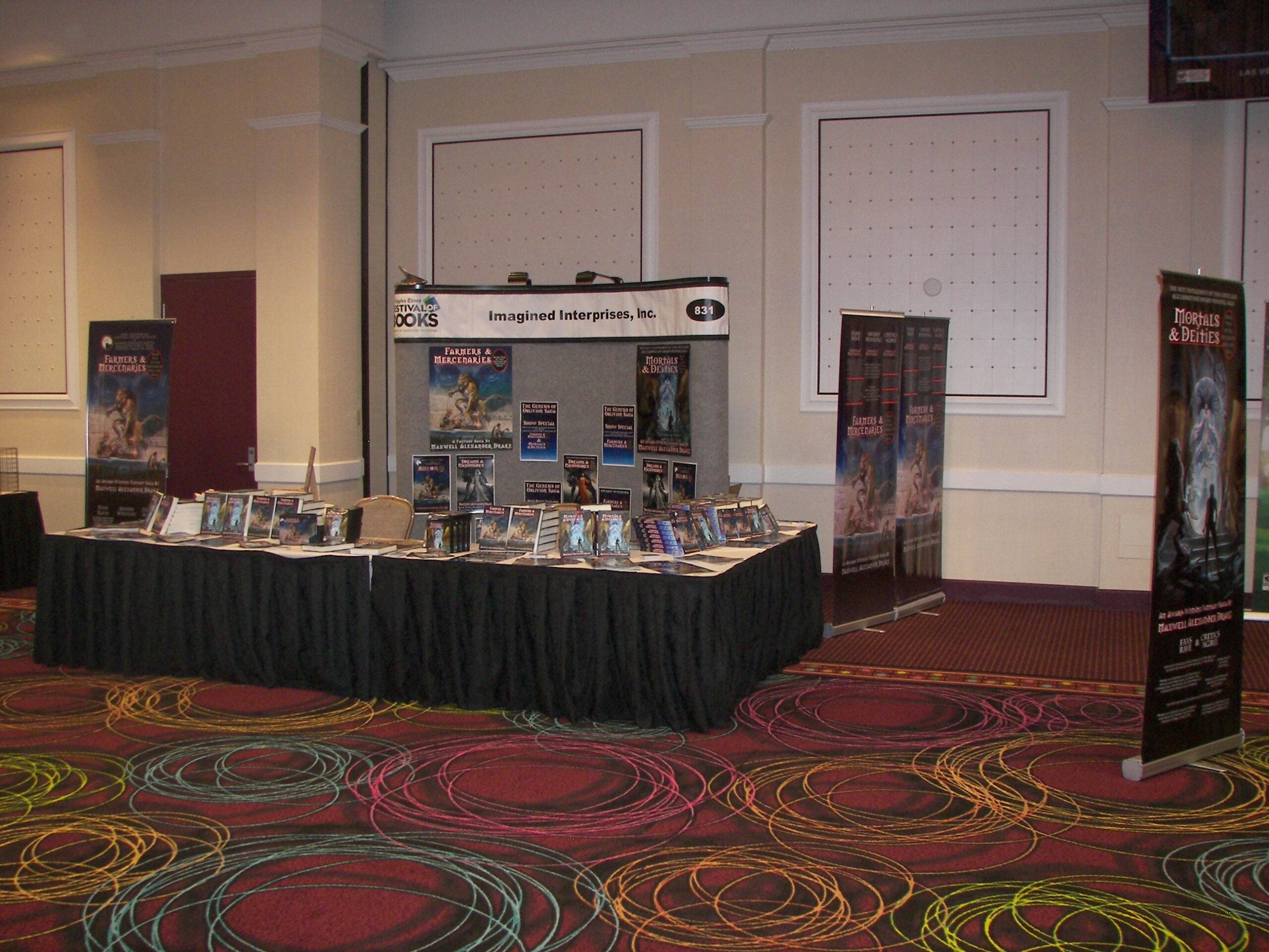 Drake's Mortals & Deities book stand at a convention